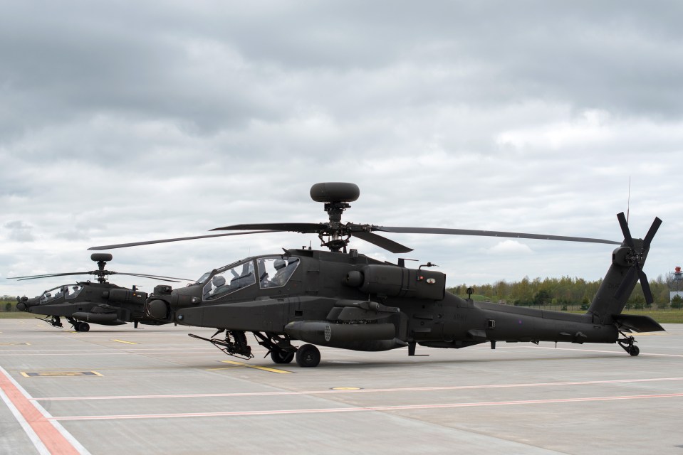 Two British Army Apache attack helicopters on a tarmac.