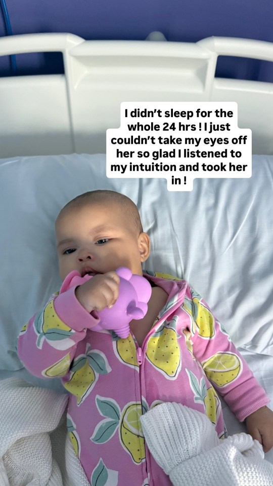 Baby in hospital bed holding a toy.