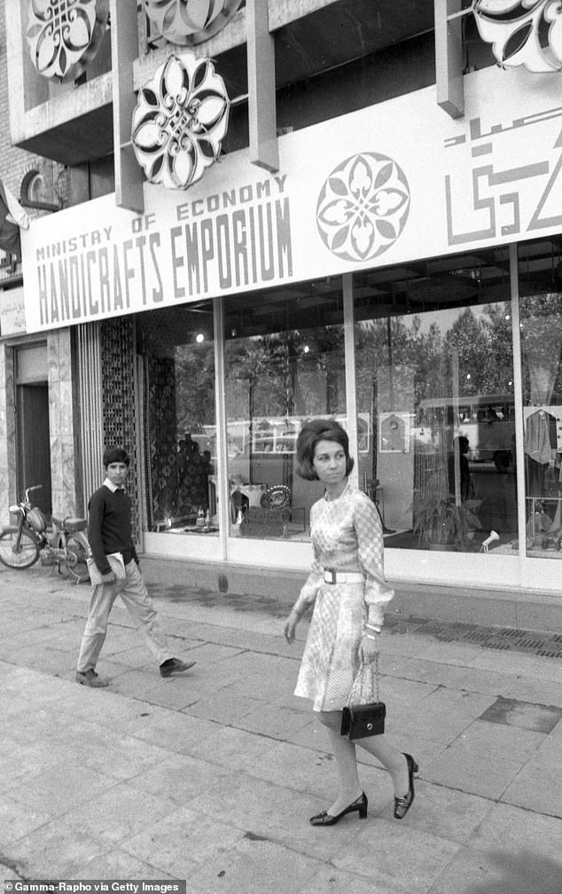 A young woman wearing a smart belted dress and carrying a handbag on a street in Tehran, 1968