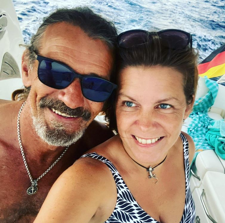 Couple smiling for a selfie on a boat.