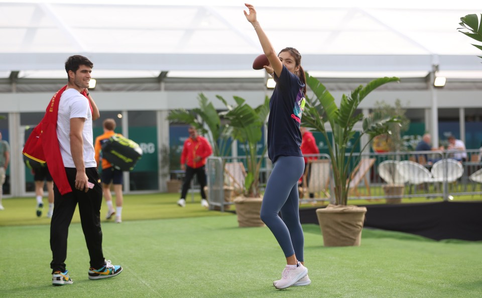 Emma Raducanu warming up with a football, Carlos Alcaraz watching.