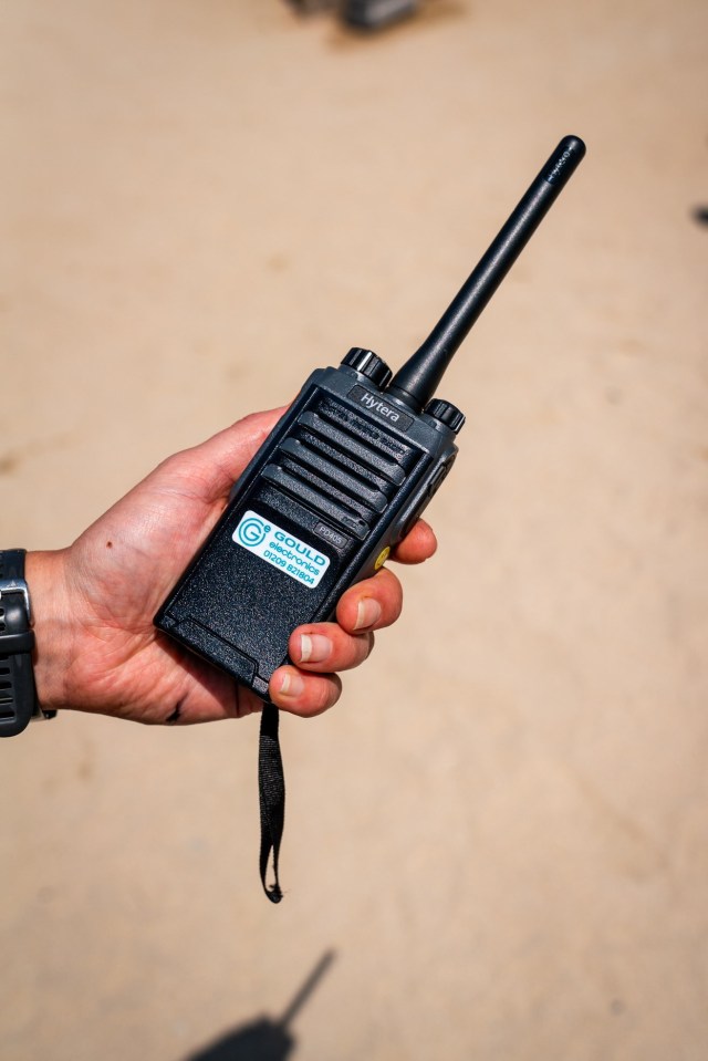 Hand holding a Hytera walkie-talkie.