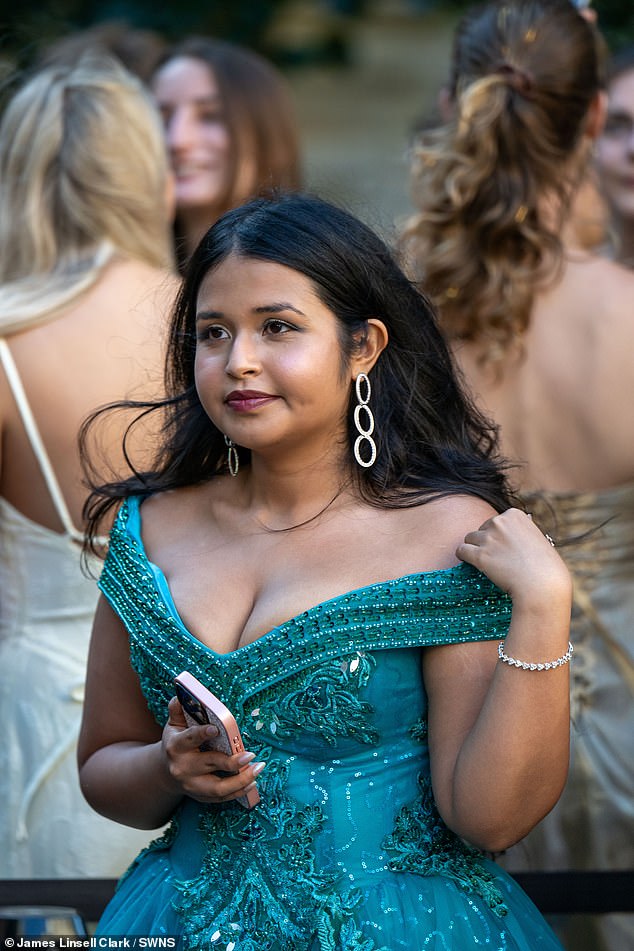 One student is pictured wearing a stunning teal sequined ball gown as she waits in line