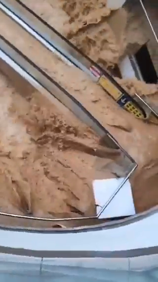 Floodwaters overflowing an escalator in a shopping mall.