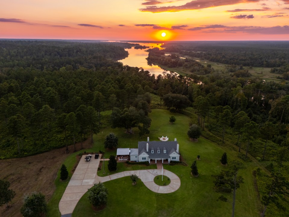 Aerial view of a large house on a ranch at sunset.
