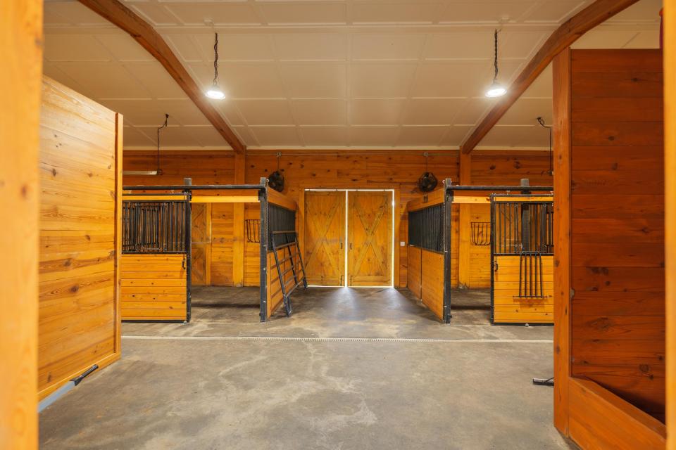 Interior of a barn with wooden stalls.