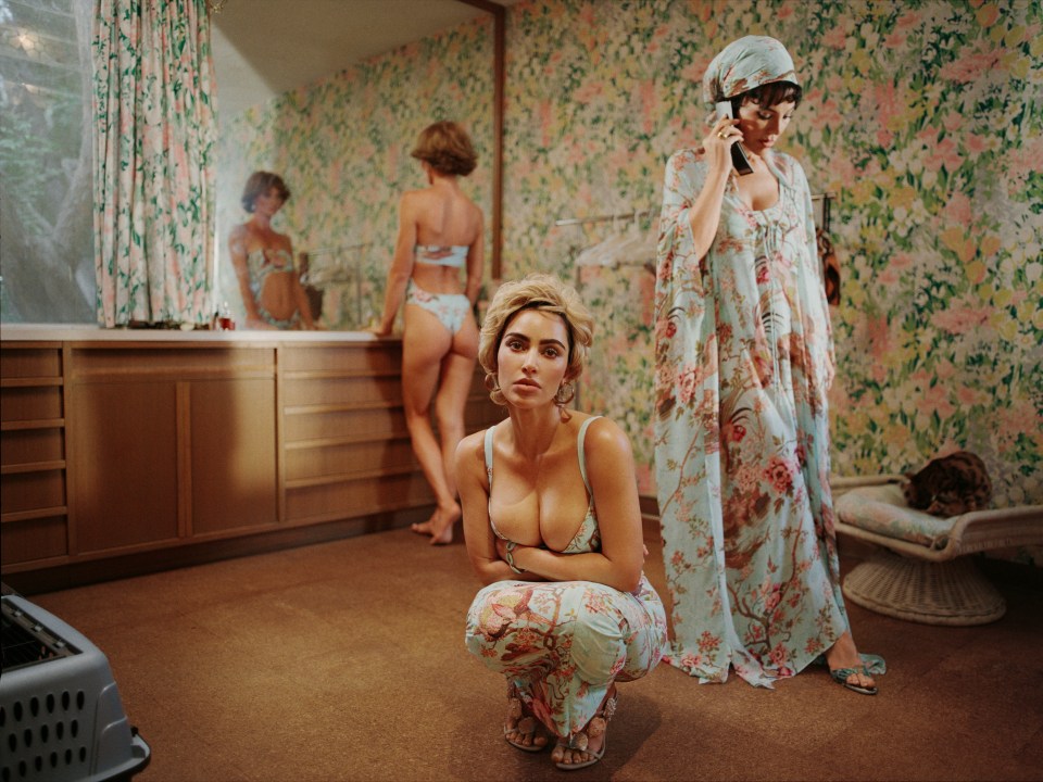 Three women in floral print lingerie and robes in a bathroom.