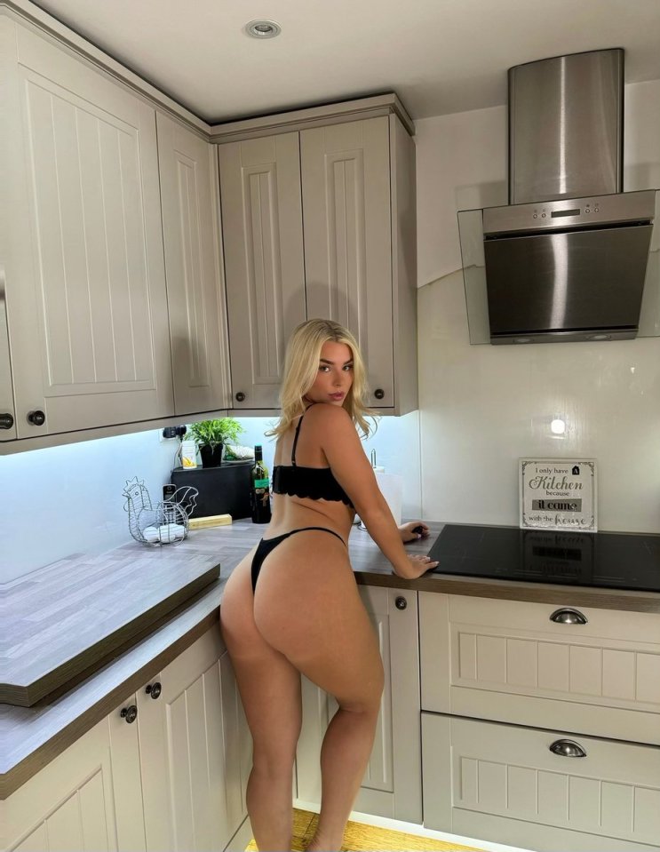 Woman in lingerie standing in a kitchen.