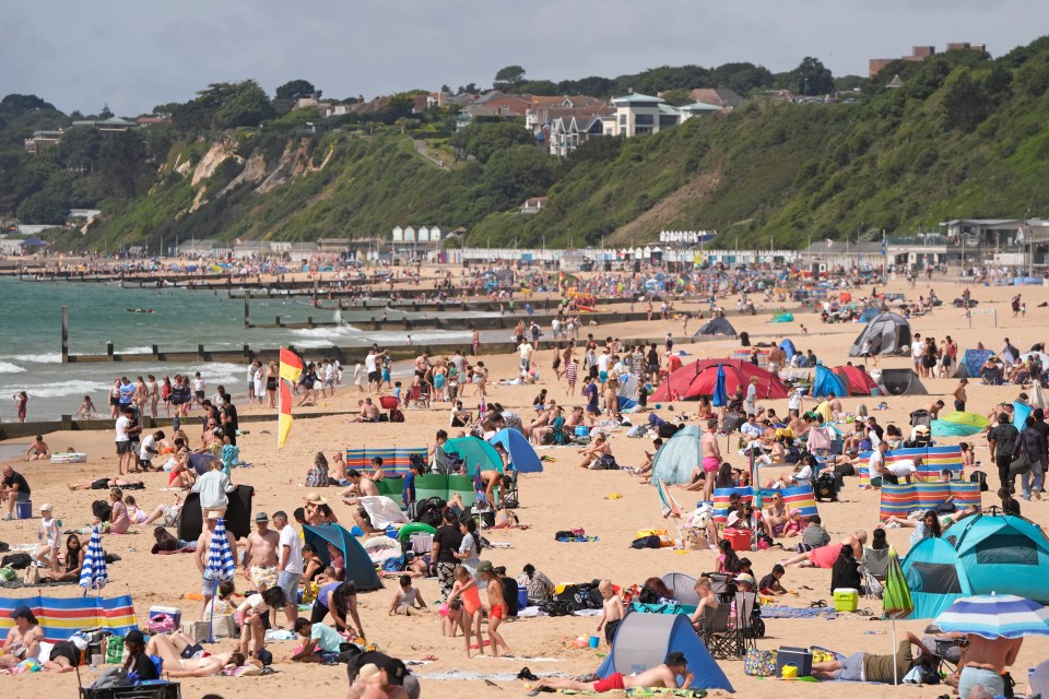 Crowded Bournemouth beach on a warm day.