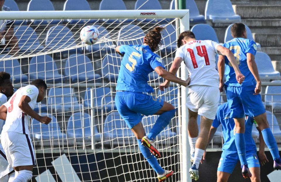 A soccer player scores a goal during a match.