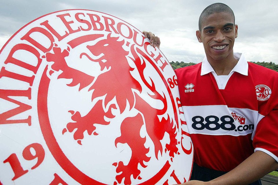 Michael Reiziger holding a Middlesbrough Football Club sign.