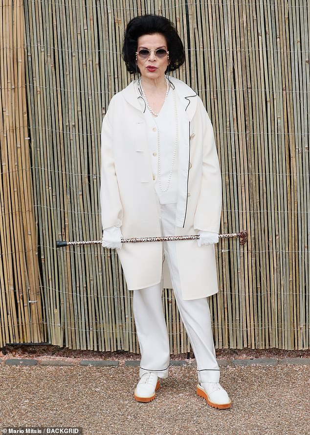 Bianca Jagger opted for an all cream ensemble, funky sunglasses and leopard print walking stick