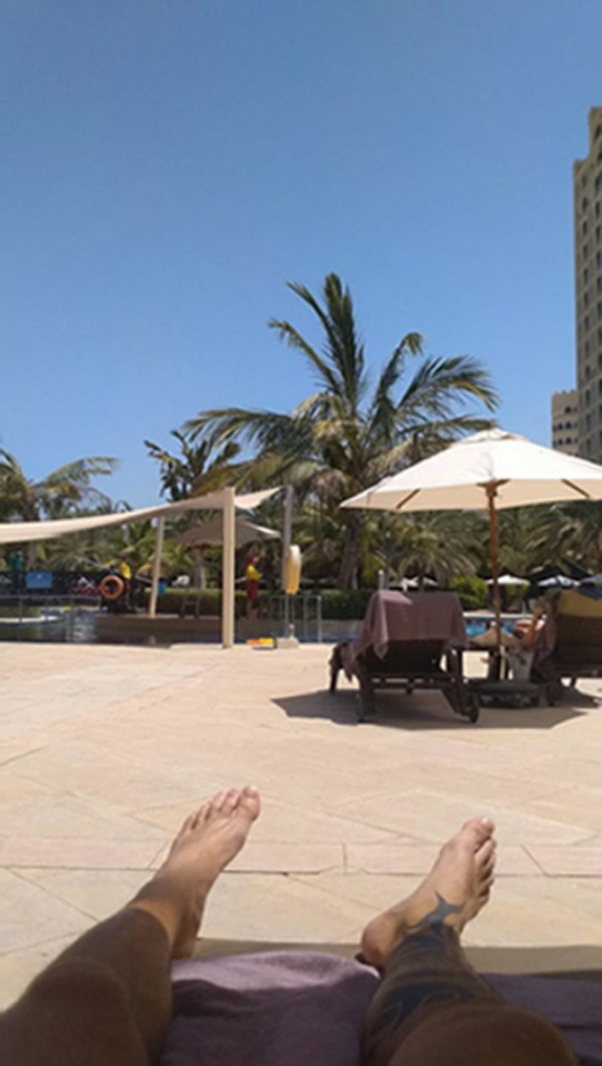 Photo of a person's feet at a resort pool.