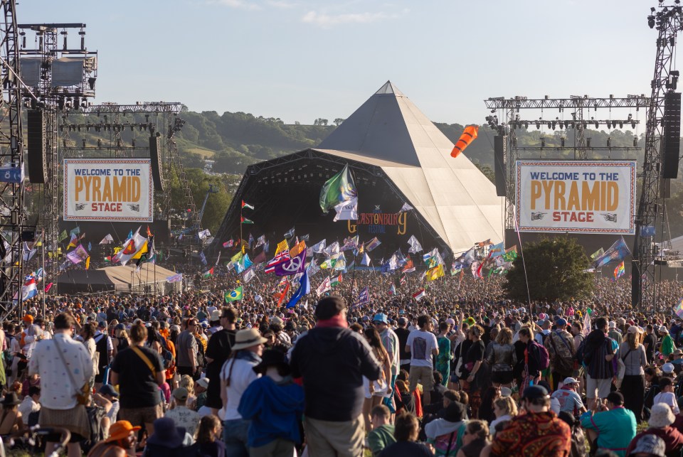 Large crowd of people at the Pyramid Stage at Glastonbury Festival.