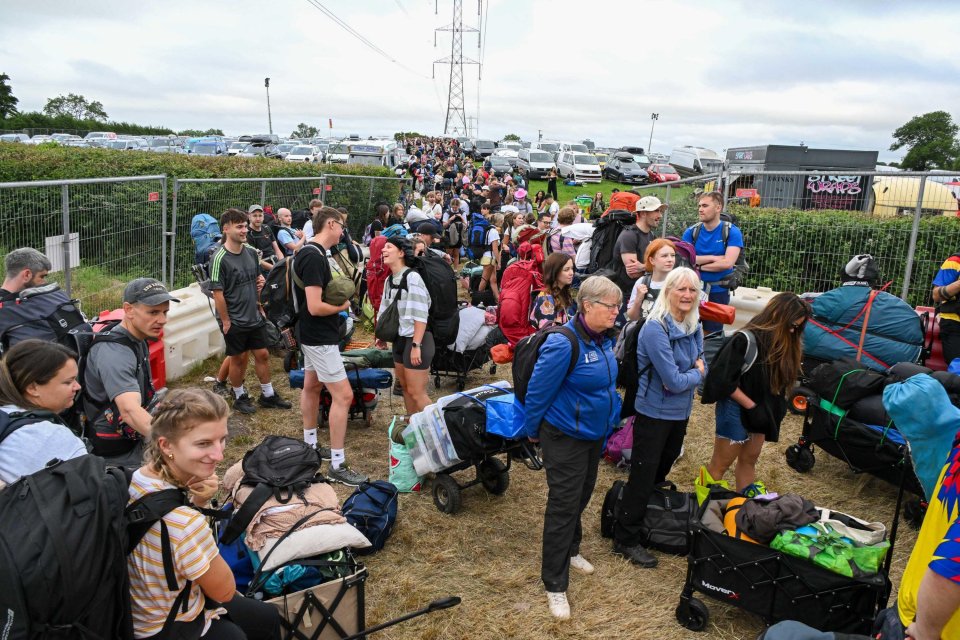 Long queue of people with luggage waiting to enter the Glastonbury Festival.