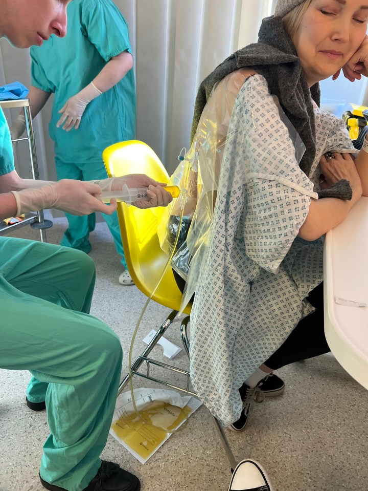 A hospital worker drains fluid from a patient's lung.