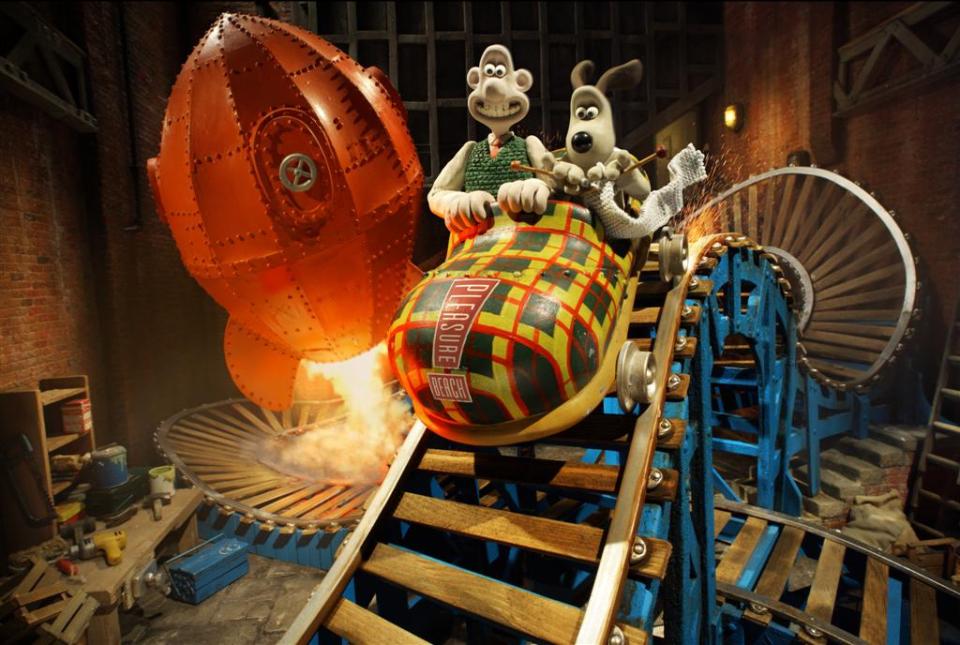 Wallace and Gromit on a rollercoaster inside a theme park ride.