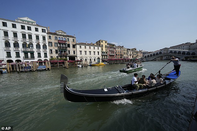 A gondolier tours tourists along the Grand Canal in Venice, Italy, on Wednesday, June 25, 2025