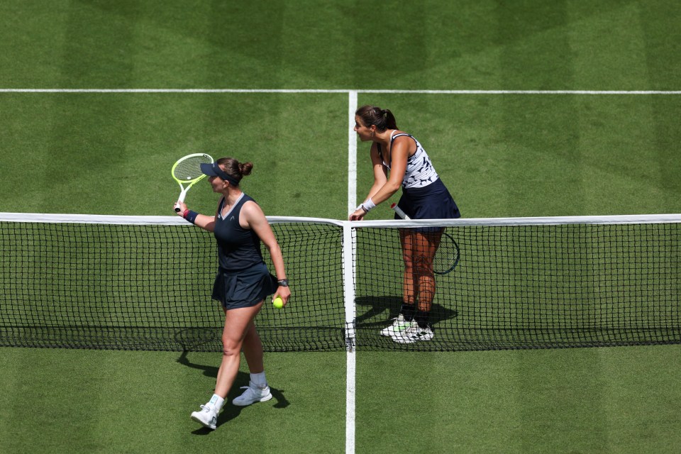 Two tennis players at the net, one arguing with the umpire.