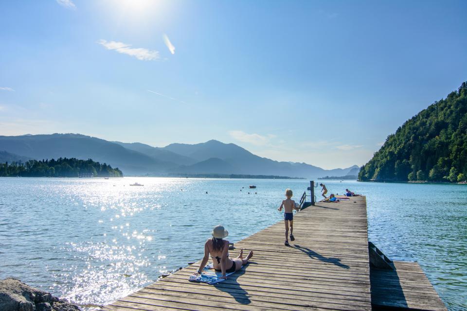 People relaxing on a jetty at Lake Wolfgangsee in Austria.