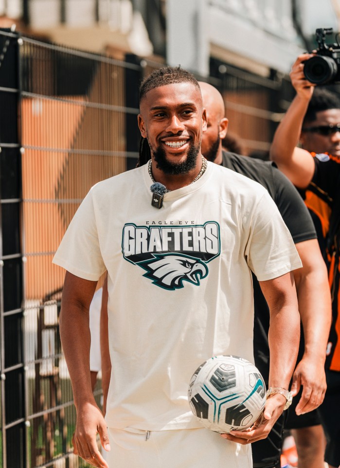 Alex Iwobi holding a soccer ball, wearing a Grafters t-shirt.