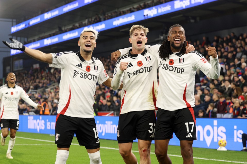 Three Fulham soccer players celebrating a goal.