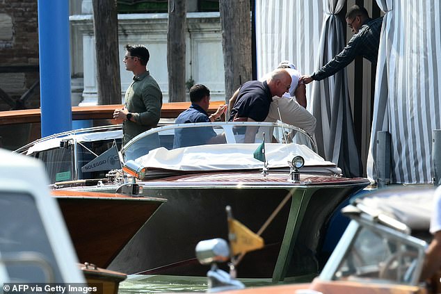 Bezos is pictured stepping off the boat
