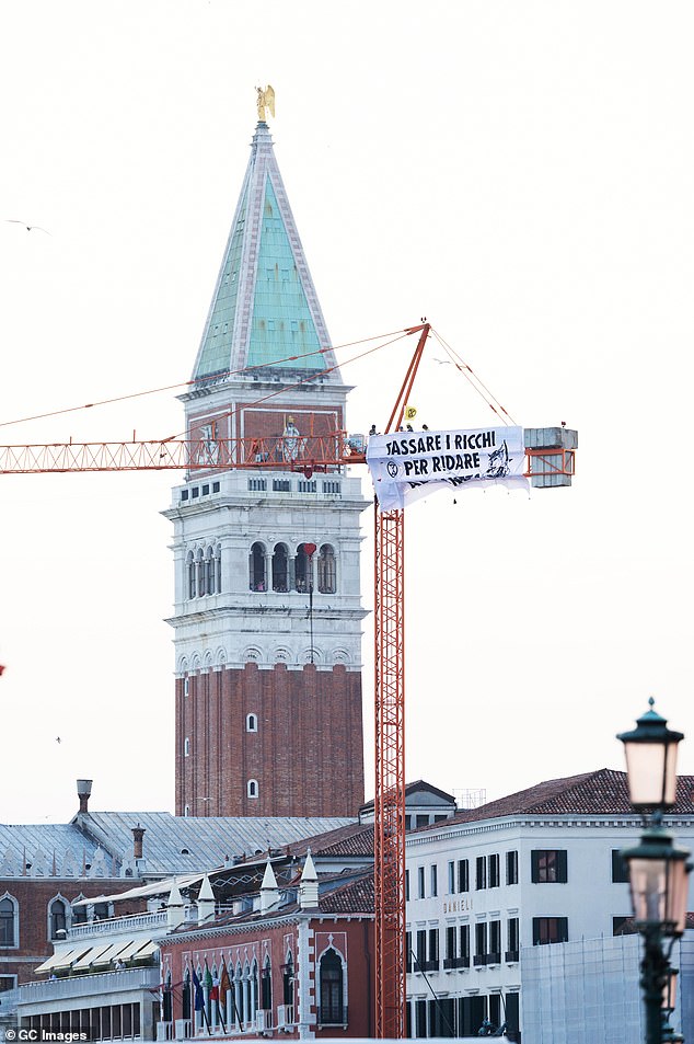 Extinction Rebellion" activists protest under the slogan "Tassare I Ricchi Per Ridare Al Pianeta" (Taxing the Rich to Give Back to the Planet) against the wedding of Jeff Bezos and Lauren Sanchez