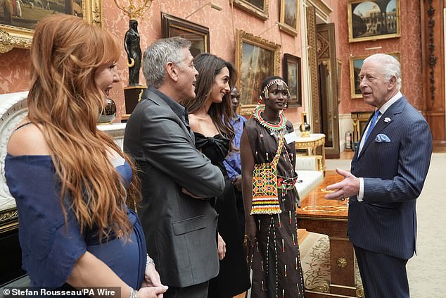 Charles appeared to be in high spirits as he chatted with George, Amal and Charlotte this afternoon