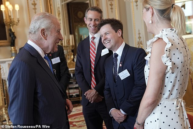 The King grinned as he enjoyed chatting with attendees for the reception at Buckingham Palace