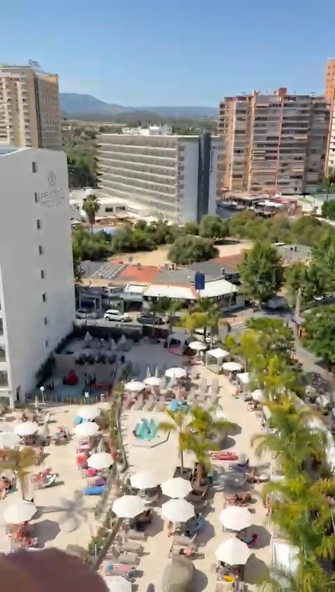 Aerial view of a Benidorm hotel pool area and surrounding buildings.