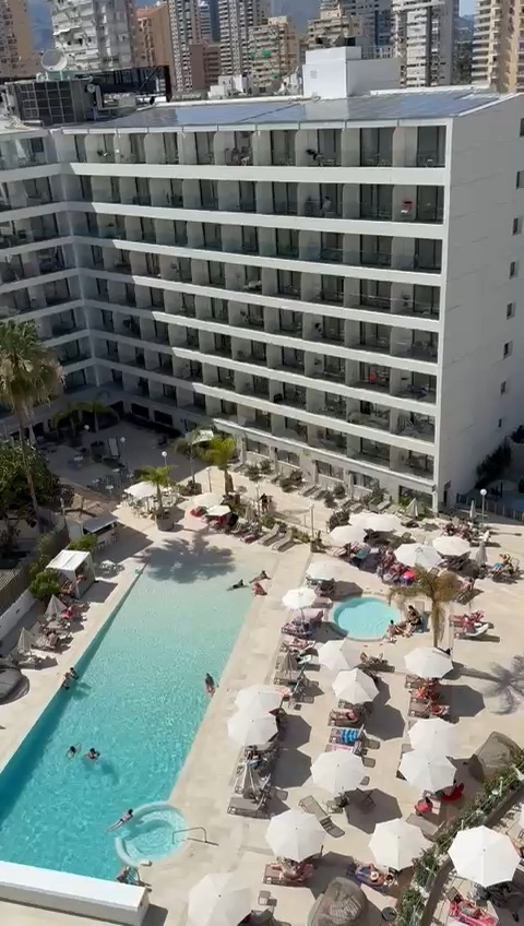 Aerial view of a Benidorm hotel with a pool and surrounding sun loungers.