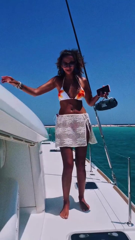 Woman in bikini and sarong on a yacht.