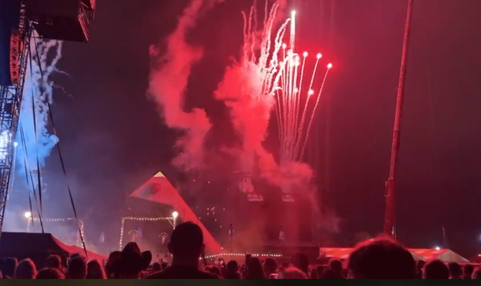 Fireworks display over a concert crowd.