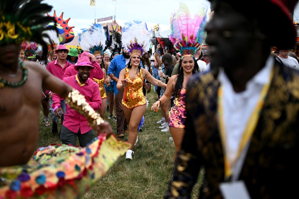 Performers in colorful costumes at the Glastonbury Festival.