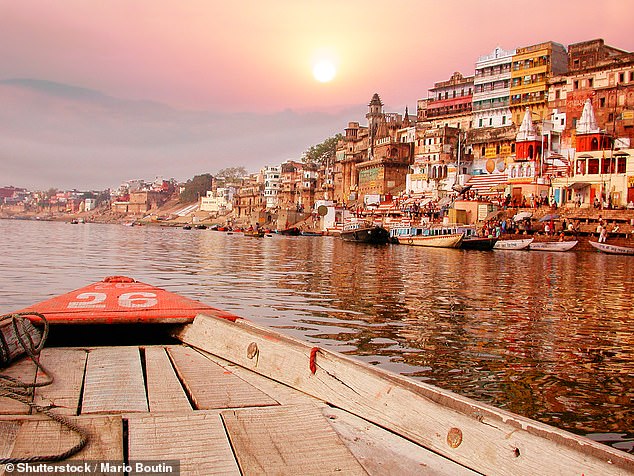 As Amol pushed his way through crowds, he was greeted with shouts of ‘Praise be to the Lord Ram!’. Pictured: The sunset river bank on the ganges in India on an old wooden boat.