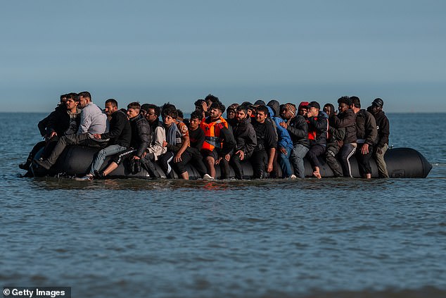 Migrants sit on a dinghy as they wait to sail into the English Channel on June 17, 2025 in Gravelines, France