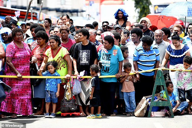 Crowds had gathered outside the market to greet the royal guests, with locals singing songs and children waving flags