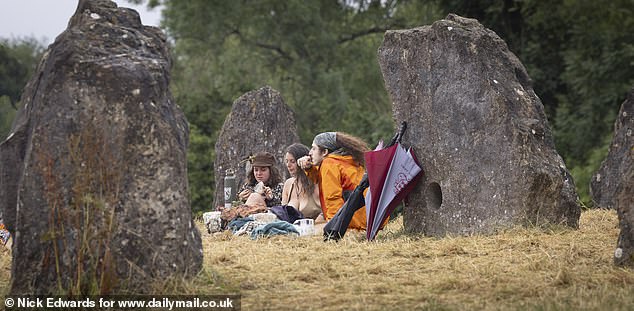 Revellers gather at the Stone Circle at Glastonbury Festival in Somerset early this morning