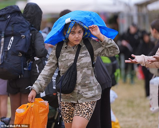 A rain shower at Worthy Farm in Somerset this morning as revellers arrive for Glastonbury