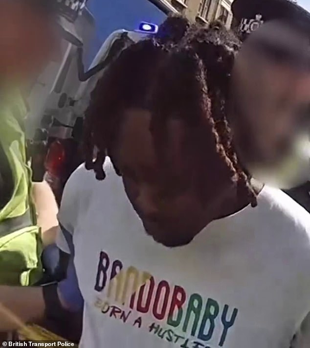 Miles can be seen bowing his head as he is handcuffed by British Transport Police officers who apprehended him using Oyster card data
