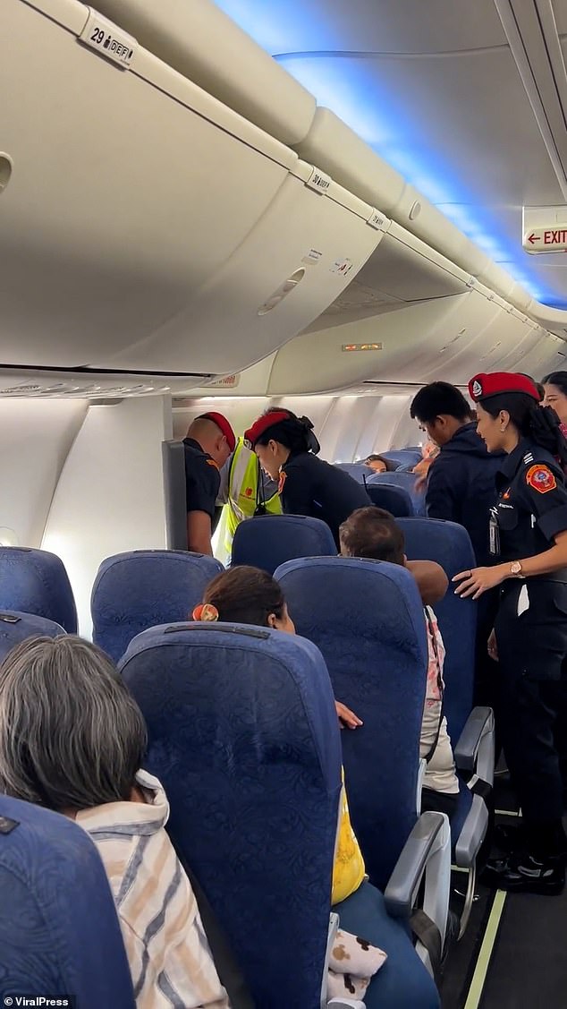 Footage shows officers yanking the stubborn passenger off his seat