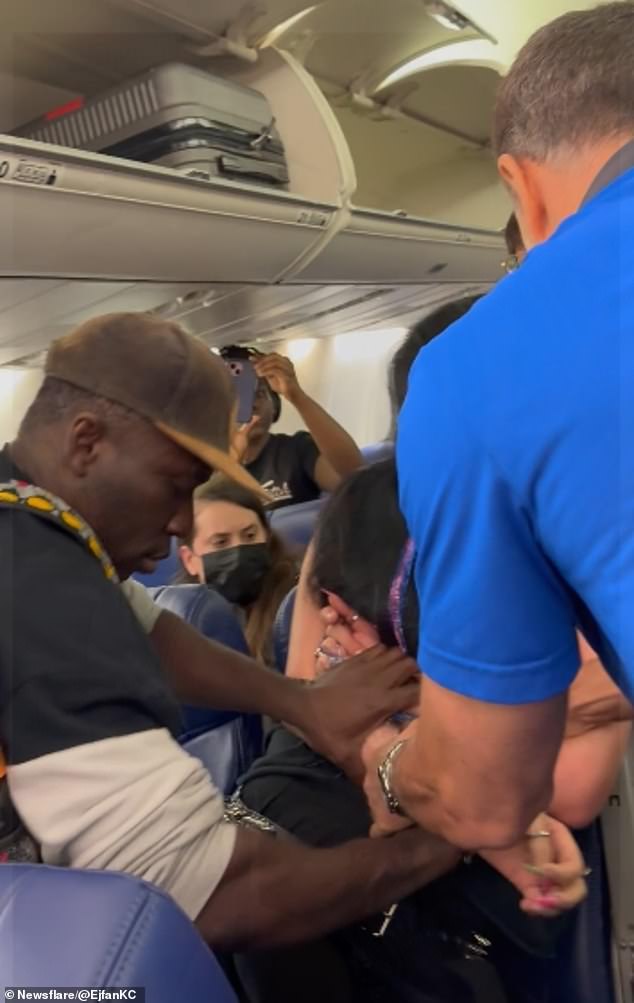 The 32-year-old repeatedly pulled another female passenger's hair, spat in her face and kicked her on a Southwest Airlines plane at LaGuardia Airport in New York. She is seen being restrained by a passenger and Southwest employees