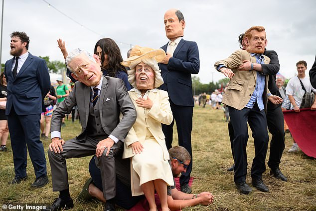 A performer dressed as Prince Harry is removed from a Royal Family group photo today