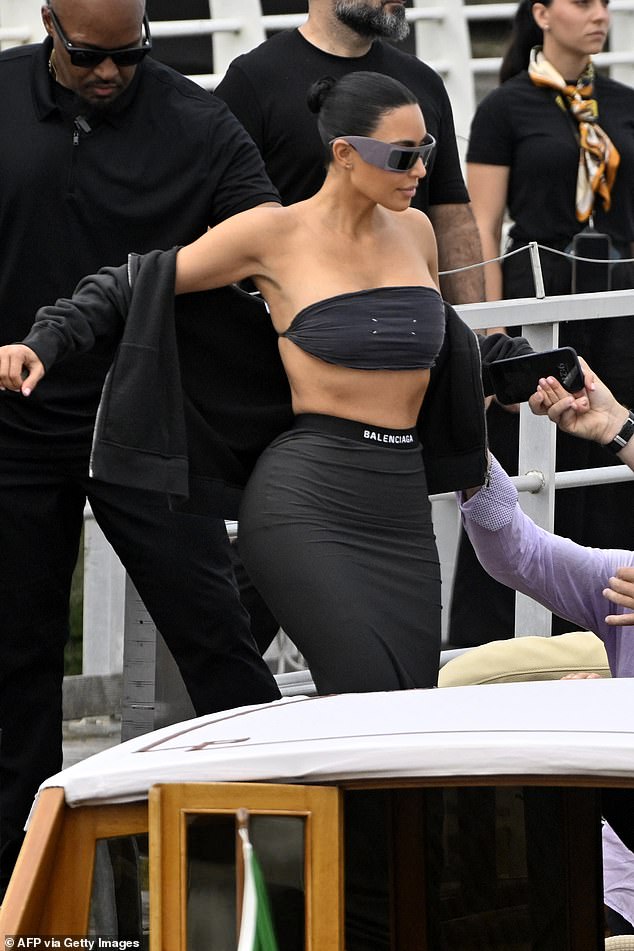 Kim Kardashian looked like she was turning up for an Ibiza DJ set in a Margiela black stretch bandeau top and a branded Balenciaga stretch black long skirt