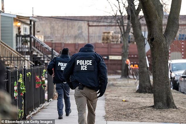ICE agents walk down a street during a multi-agency targeted enforcement operation in Chicago