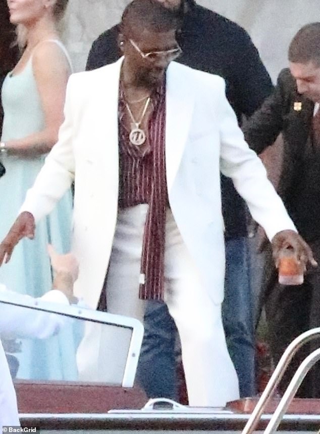 Blast from the past! Singer Usher arrived on Thursday for the festivities in a suit that looked like it was from the 1980's and striped blouse underneath. He also wore a big necklace with a 'U' pendant on it, and wire glasses