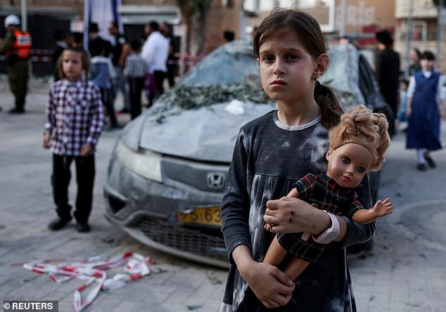 A girl carries a doll at an impact site following Iran's strike on Israel, amid the Iran-Israel conflict, in Haifa, Israel, June 22, 2025