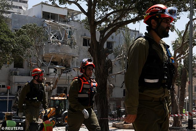 Members of the Israeli forces work at an impact site following Iran's strike on Israel, amid the Iran-Israel conflict, in Haifa, Israel, June 22, 2025