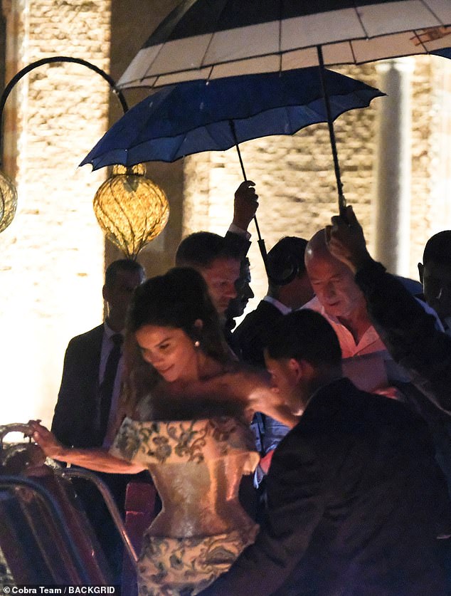 Thursday night's star-studded soiree was brought to an early end due to the intense downpour; Sanchez and Bezos pictured leaving the party